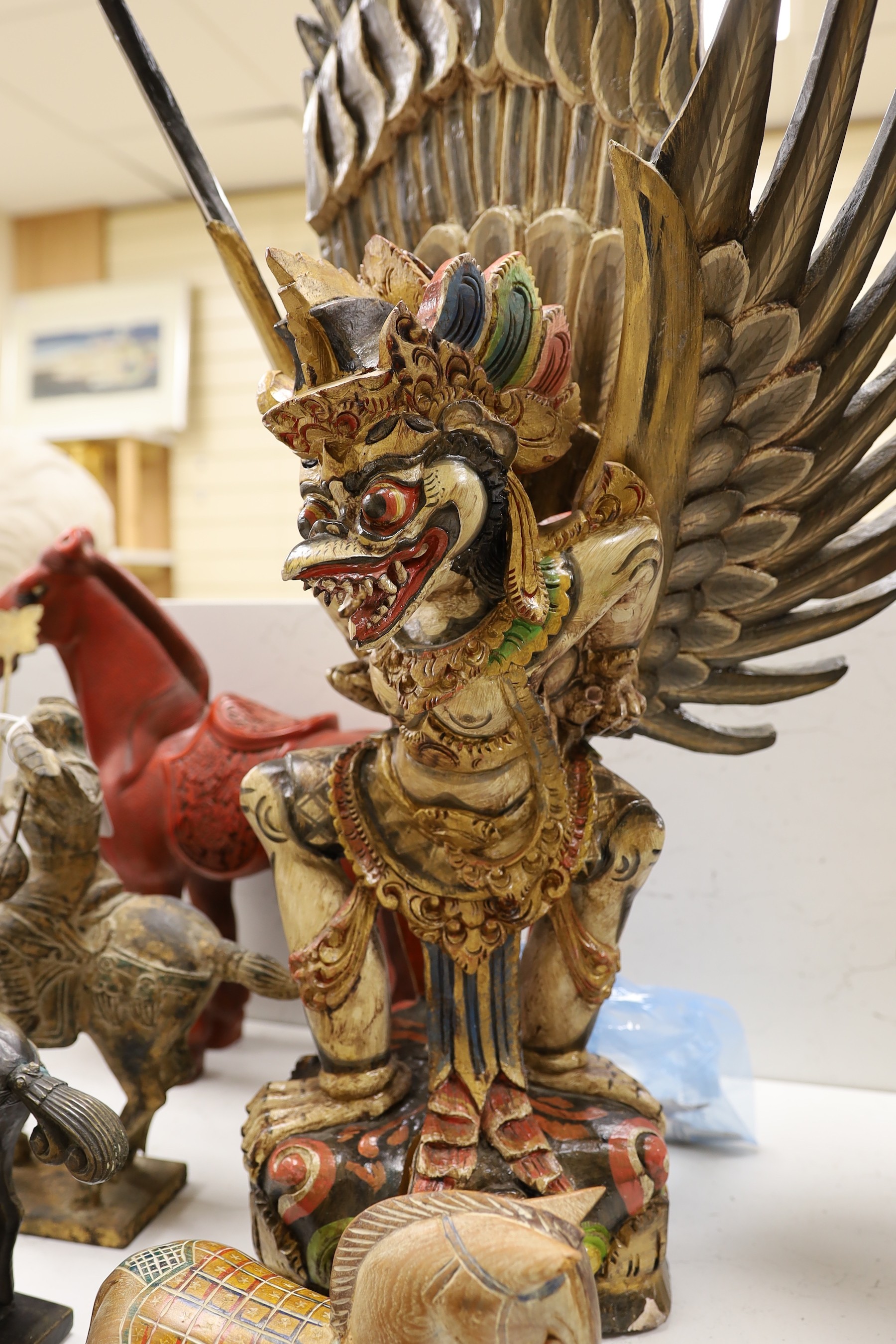 A quantity of south East Asian wood carvings including Chinese wood panels and an Indonesian carving of Garuda 80cm